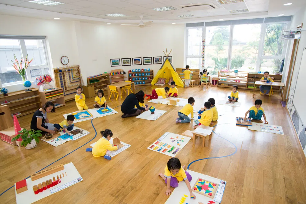 childrens are learning how to paint on floor at montessori school