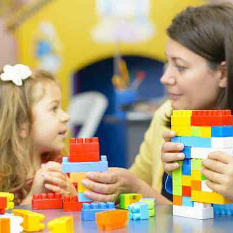 Children are playing with cubes with teacher
